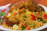 Plato de arroz con chancho servido con presas de cerdo doradas y salsa criolla